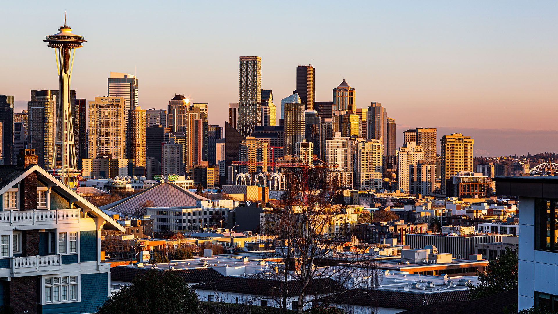 The Space Needle and downtown Seattle bathed in golden light at sunset.