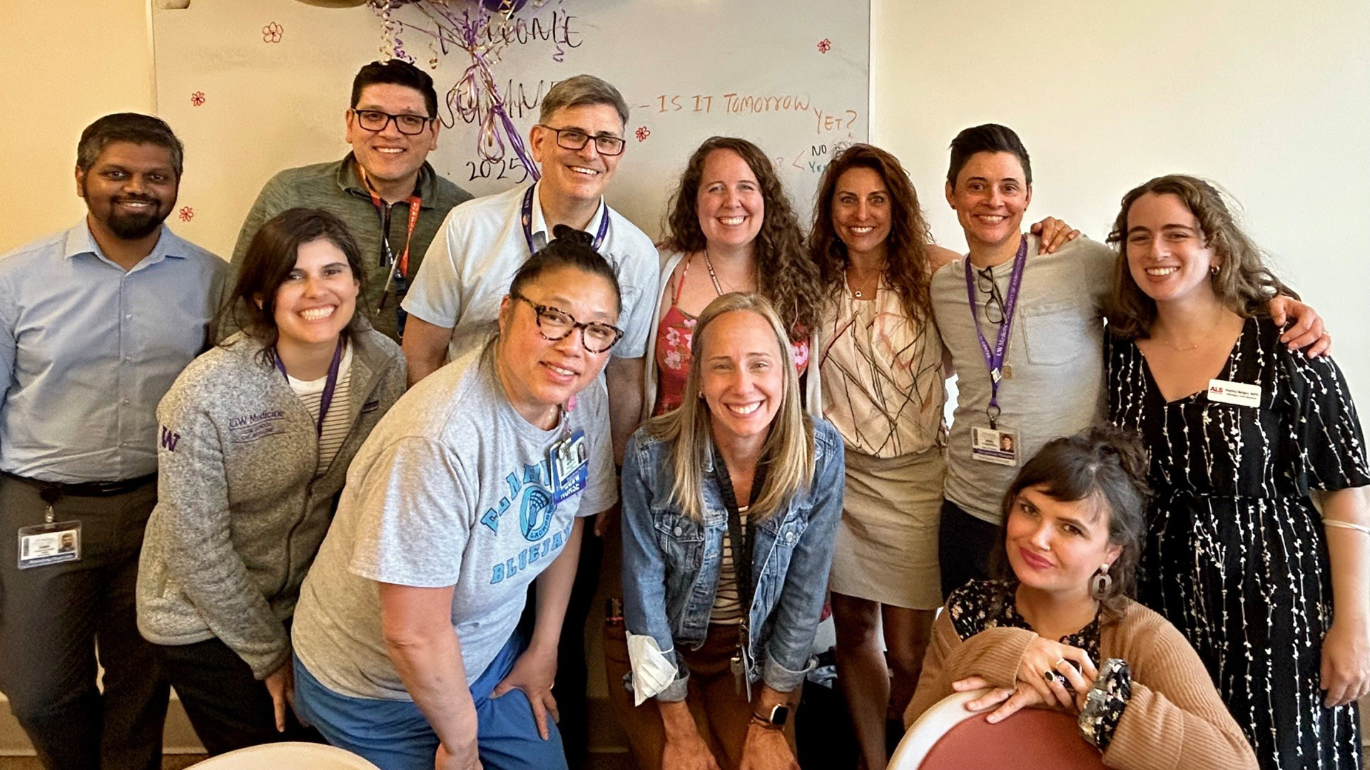 A group of eleven people pose together, smiling at the camera.