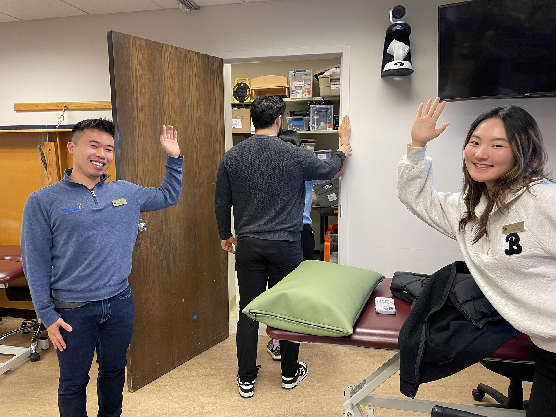 Three students hold up their arms, bent at the elbow in a high-five gesture.