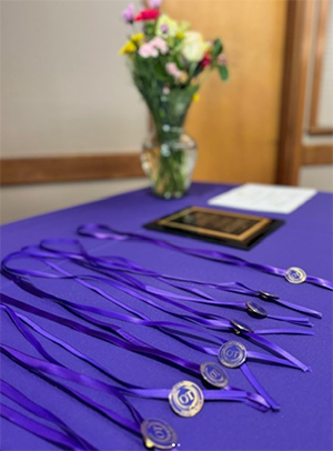 OT pins sit on a purple tablecloth.