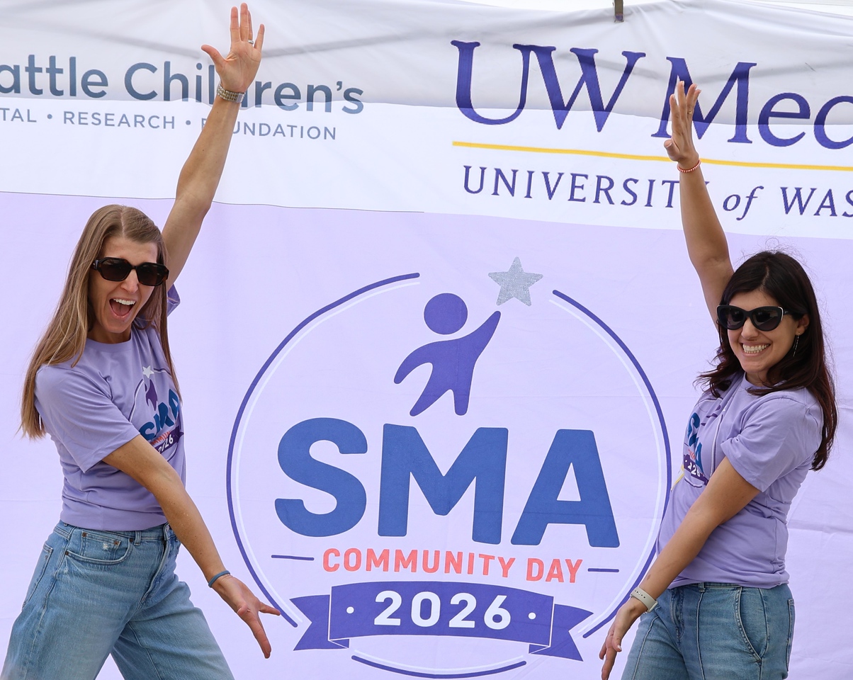 Two women stand in front of a SMA Community Day 2026 banner.