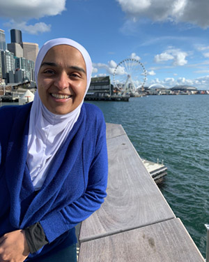 Reham Abuatiq stands on the waterfront in Seattle on a sunny day.