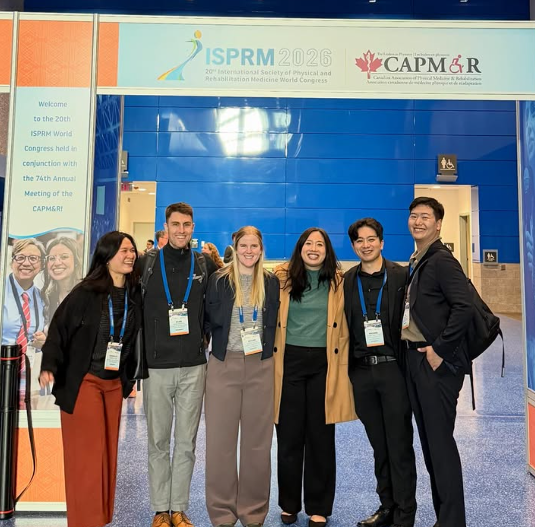 A group of people smile under a ISPRM 2026 banner.