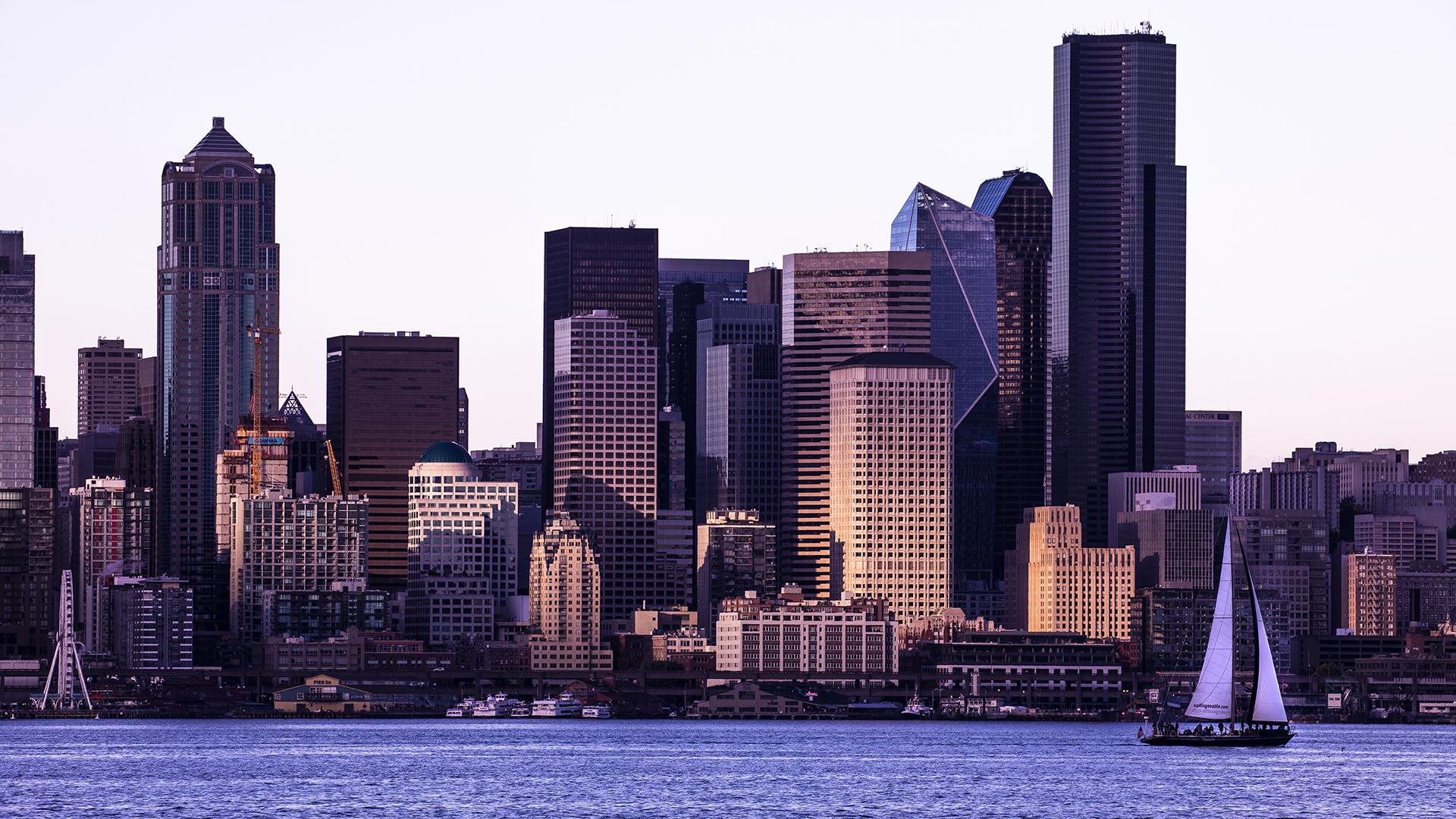 A view of downtown Seattle across the water, in a soft purple light.