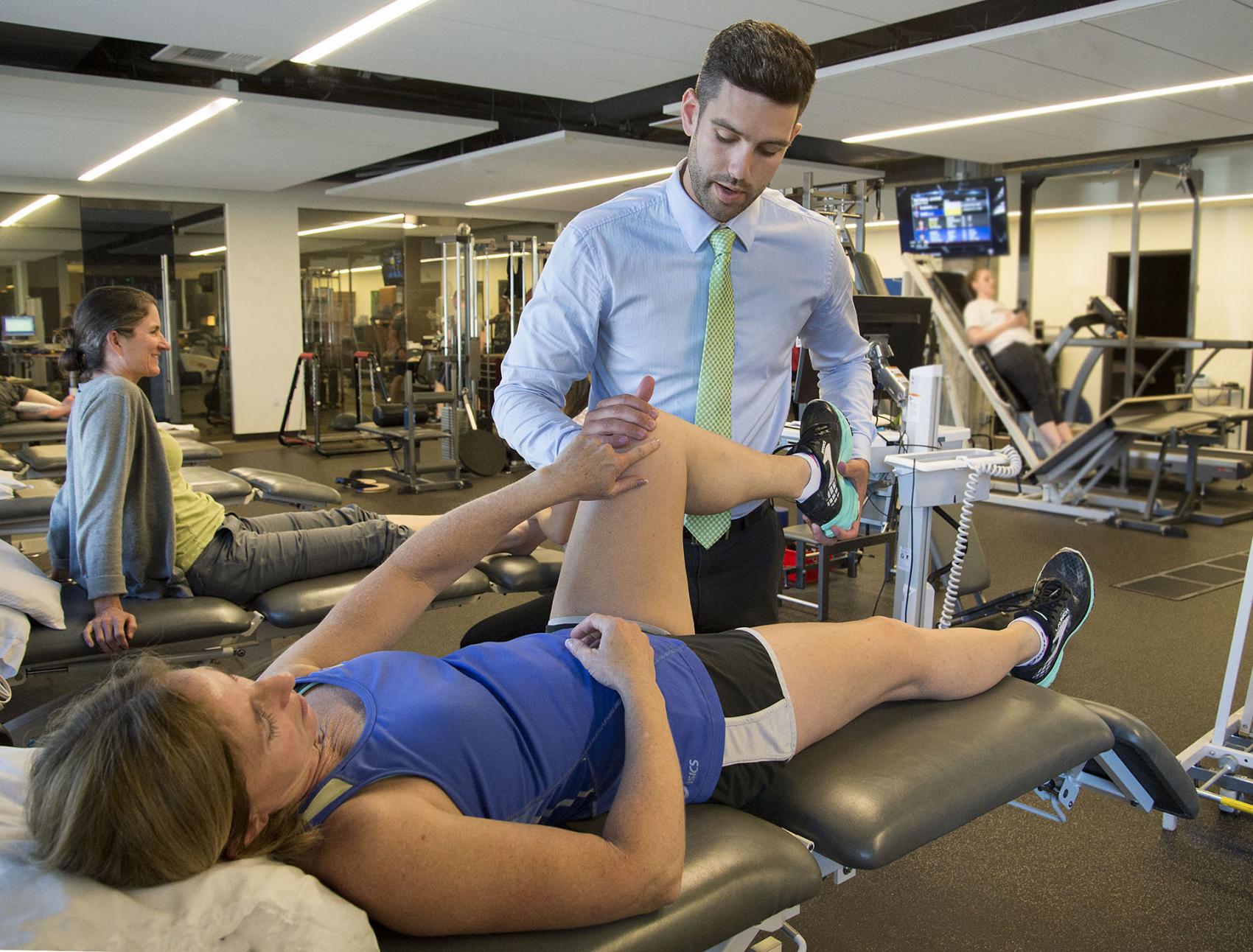 A physical therapist examines a patient's knee.  