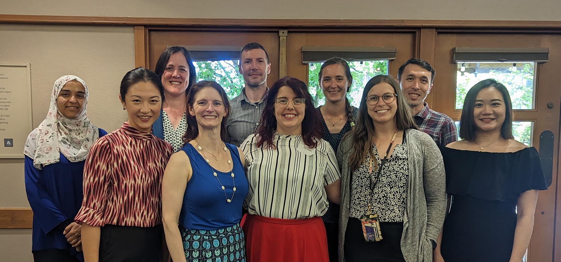 A diverse group of Rehabilitation Science PhD students stand together at the 2023 Lehmann Day Symposium. 