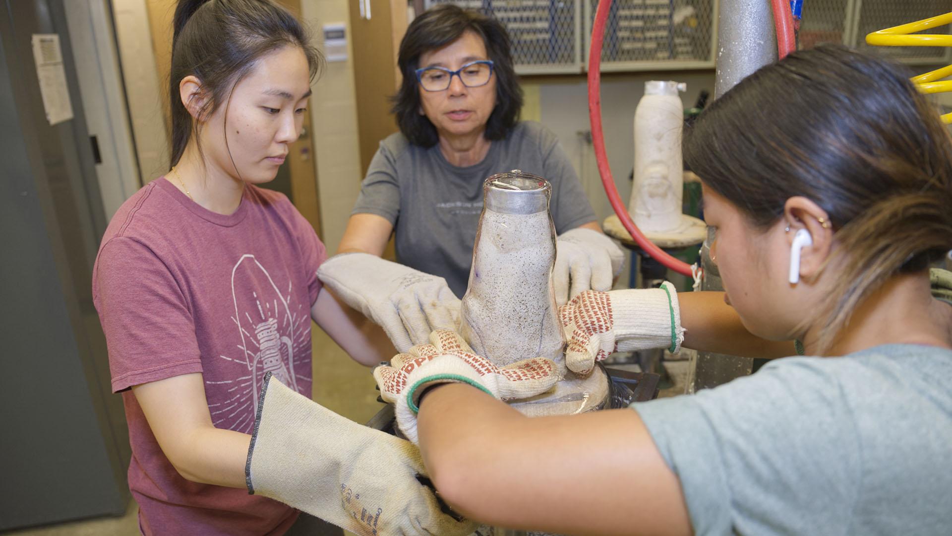 Students practice molding plastic for a prosthetic around a plaster cast of a patient's leg.
