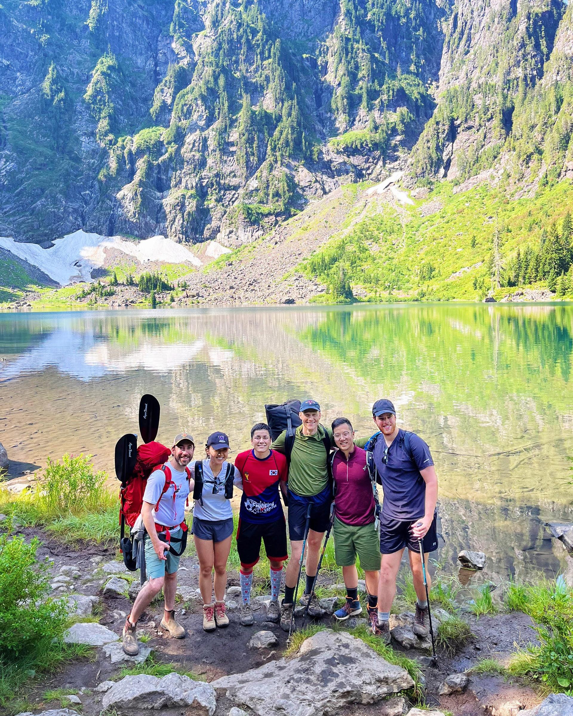 Residents on a hike stand by a beautiful PNW lake. 