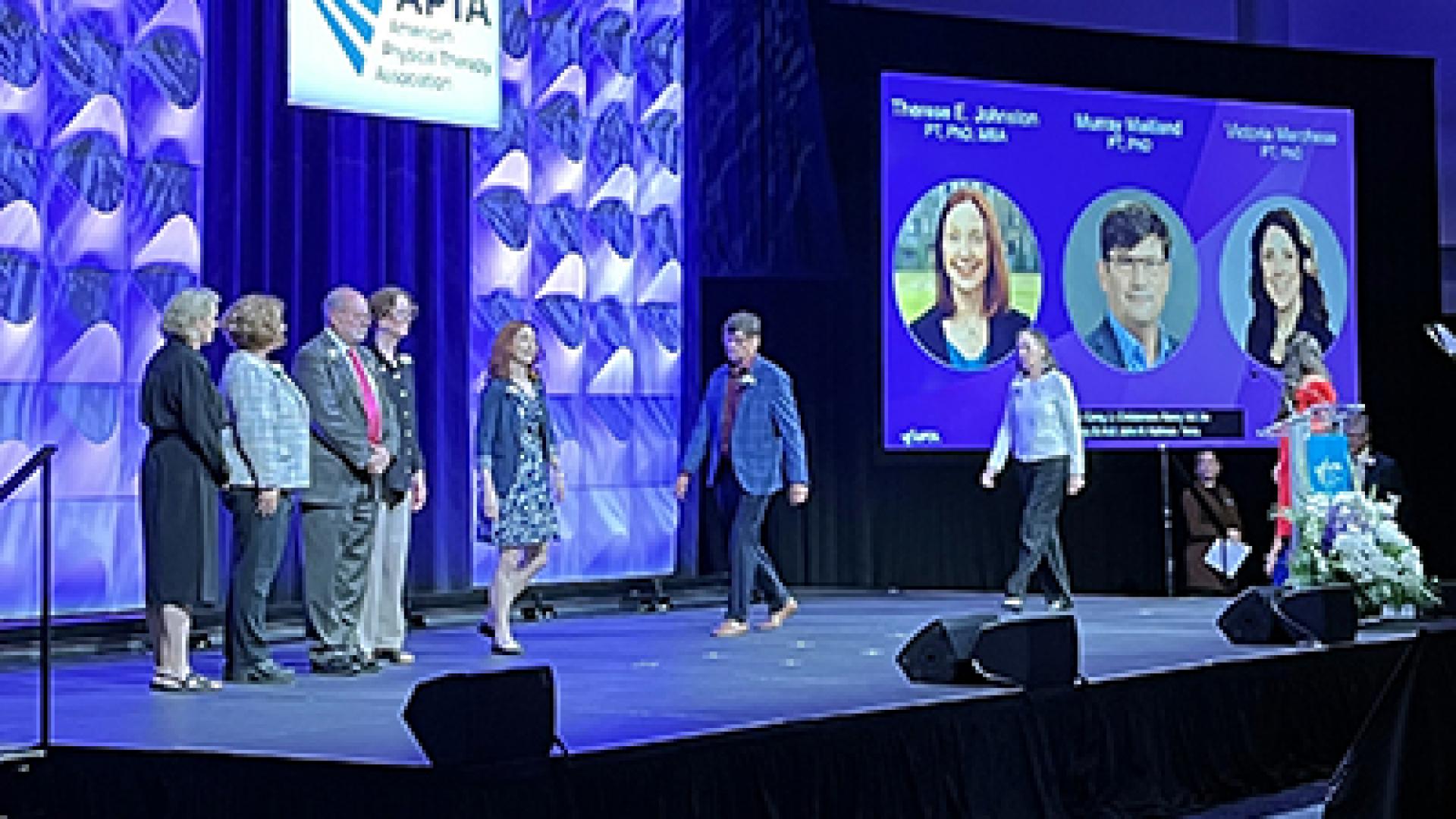 Murray Maitland walks across the APTA stage with other Catherine Worthingham Fellows. 