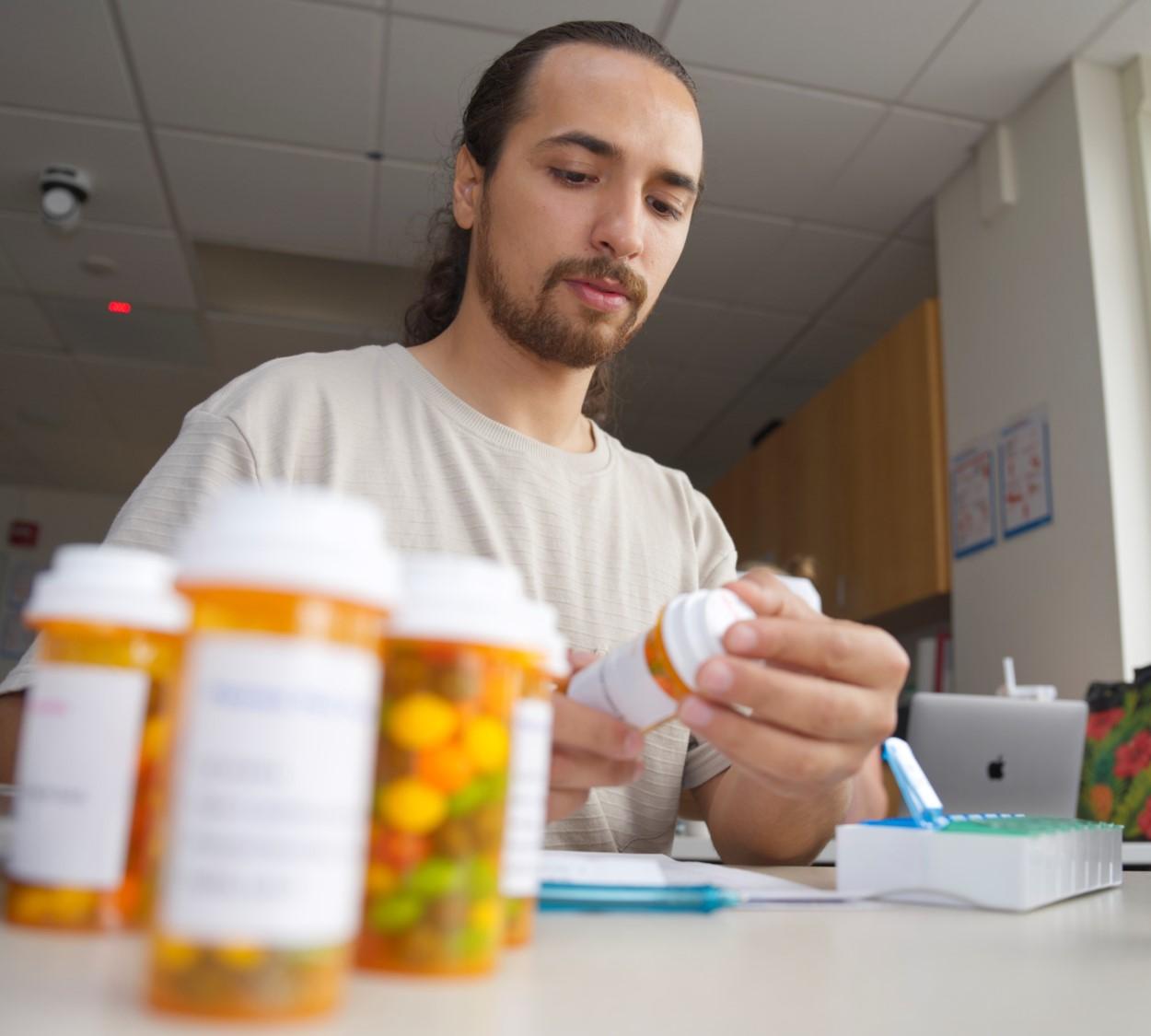 1 student organizing pills and bottles.