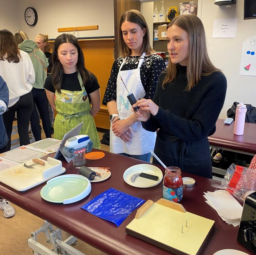 3 students demonstrating cooking devices.