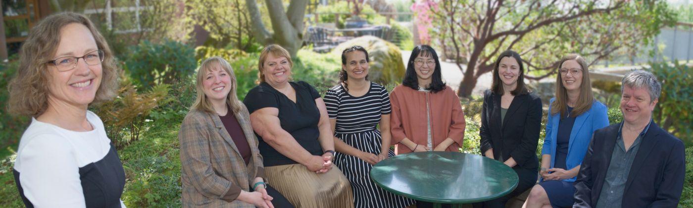 8 faculty grouped around a garden table