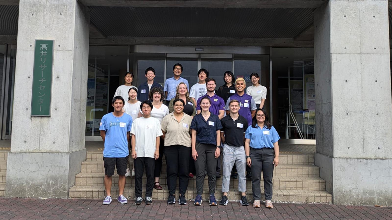 Students stand on the steps of a building at Kyoto University.