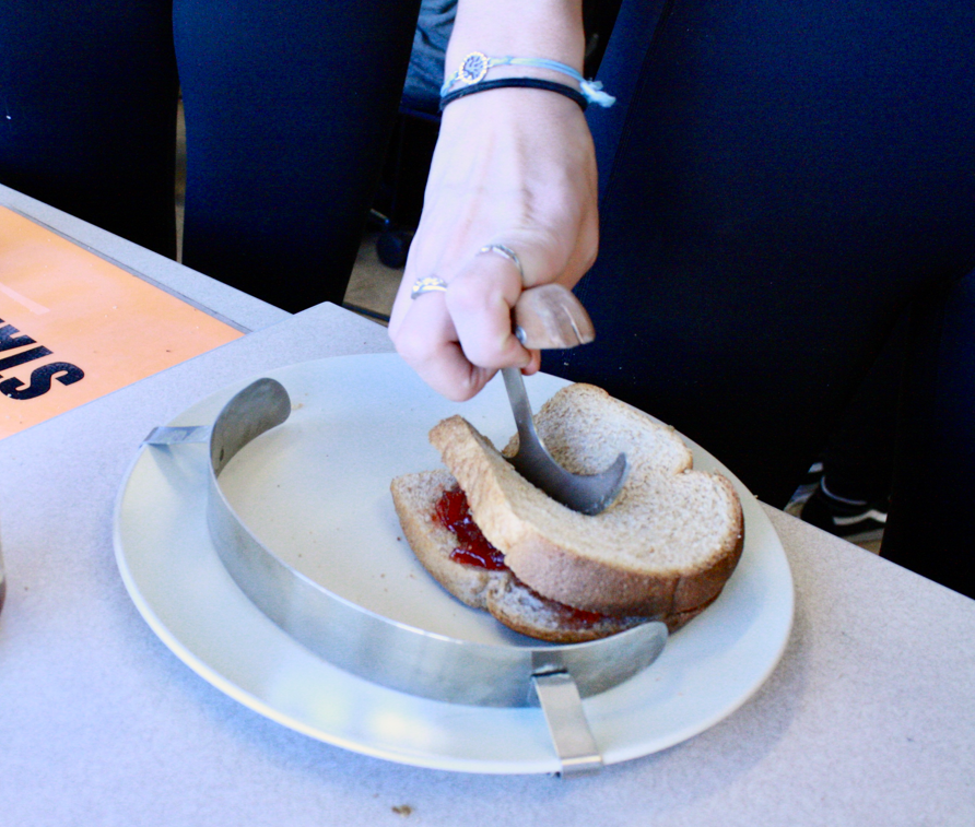 Using assistive technology to cut a sandwich.