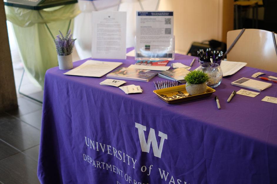 A welcome table covered in a purple tablecloth. 