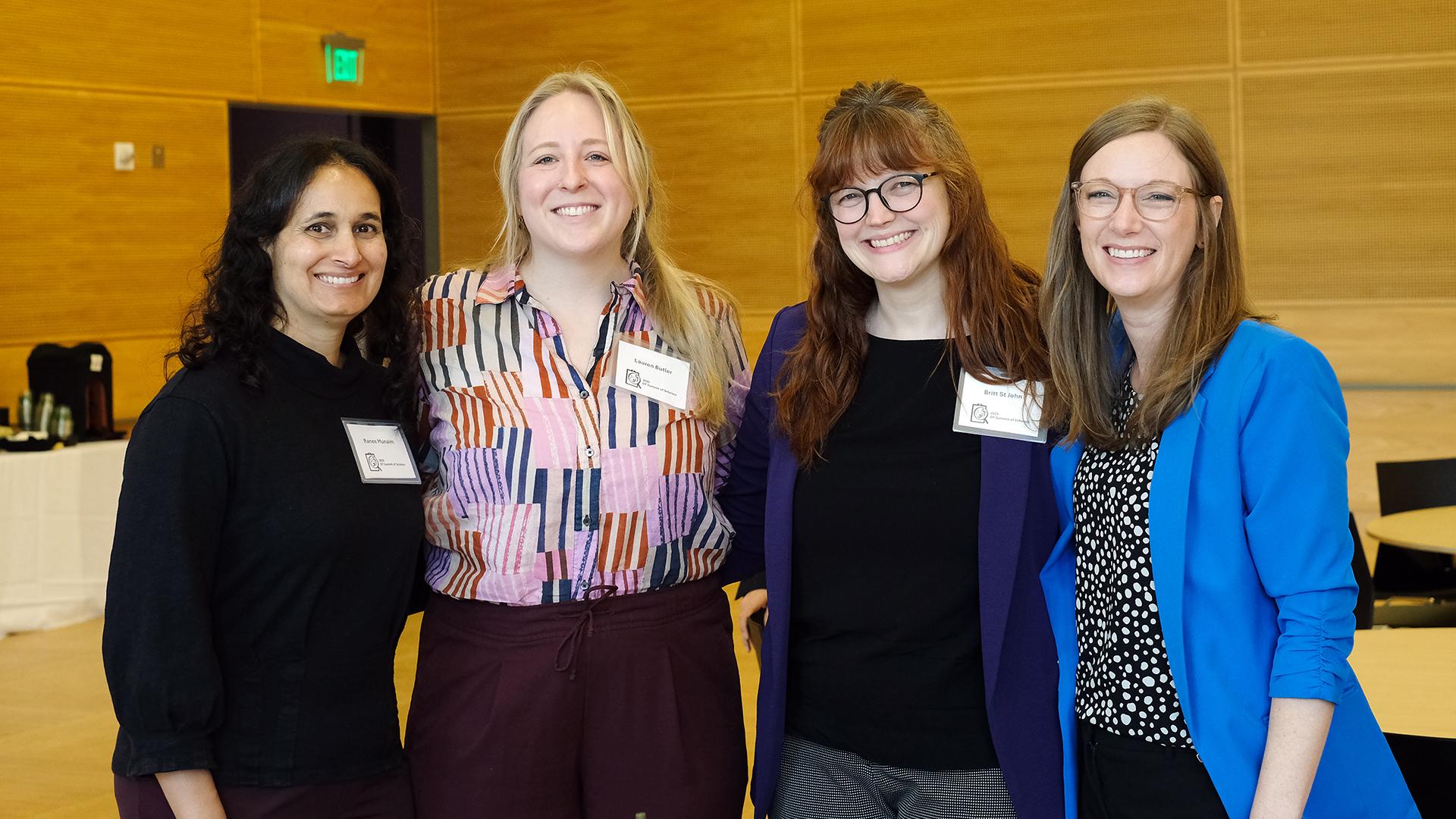 Four women smile at the camera. 