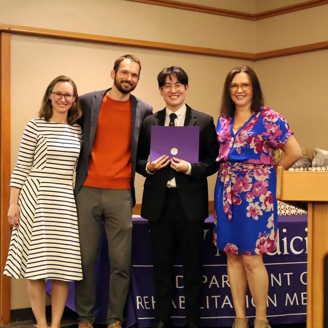 Four people smile at the camera.