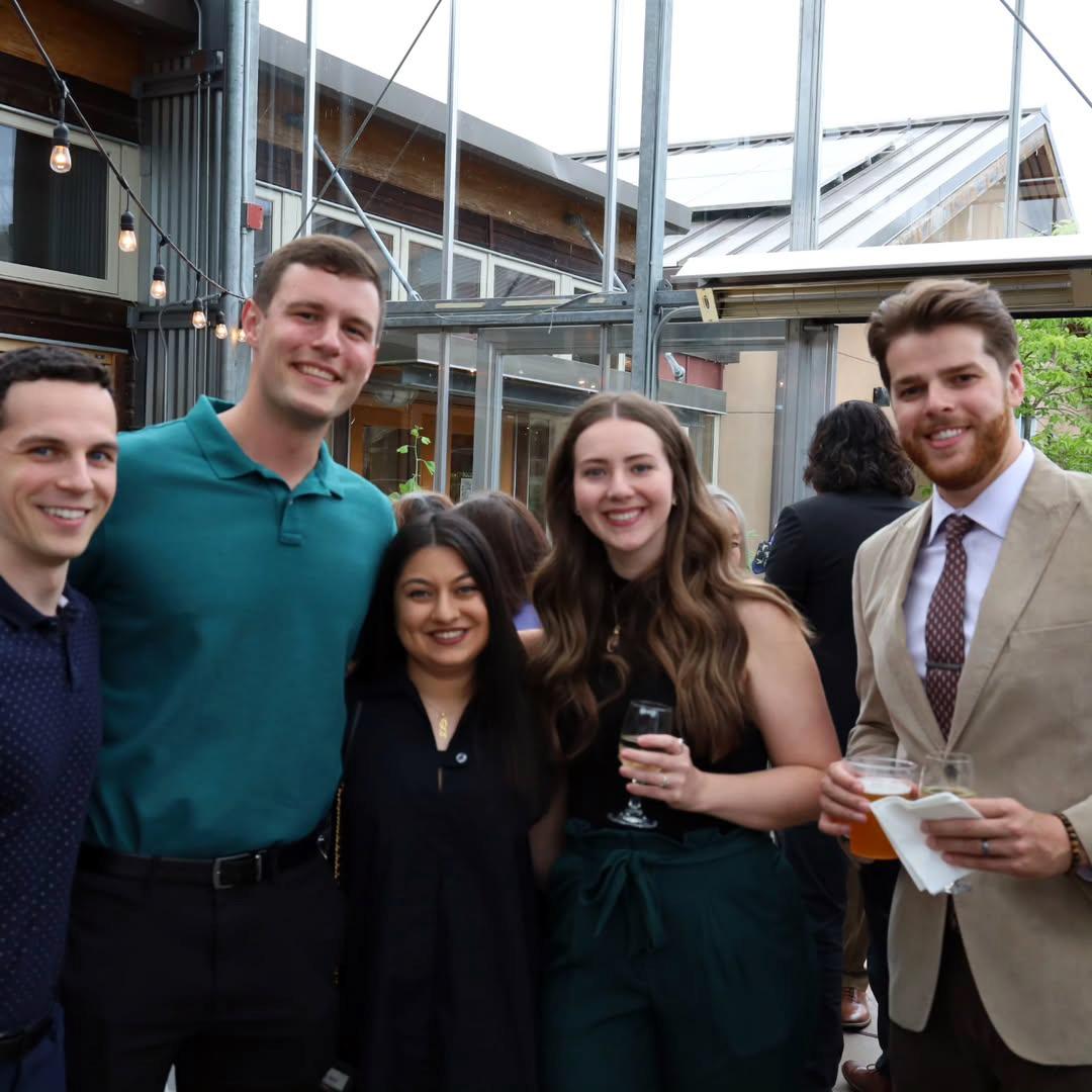 A group of five smile at the camera.