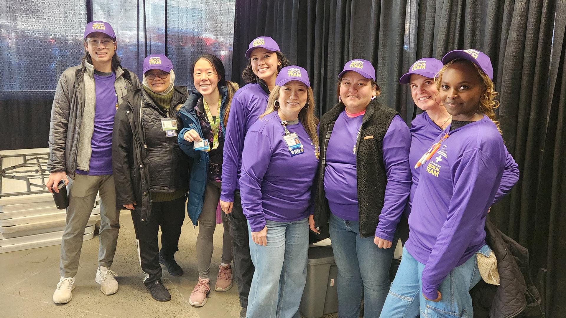 A group of people in purple shirts pose for the camera. 
