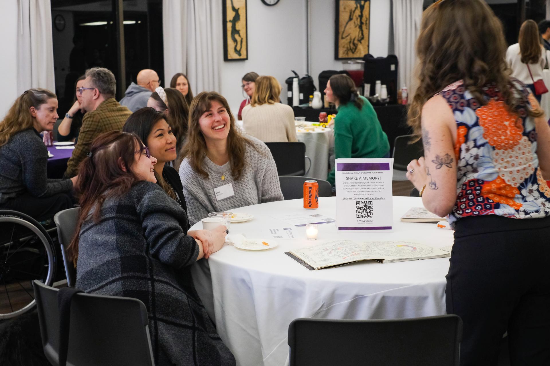 Friends pose for a photo in a crowded party room. 
