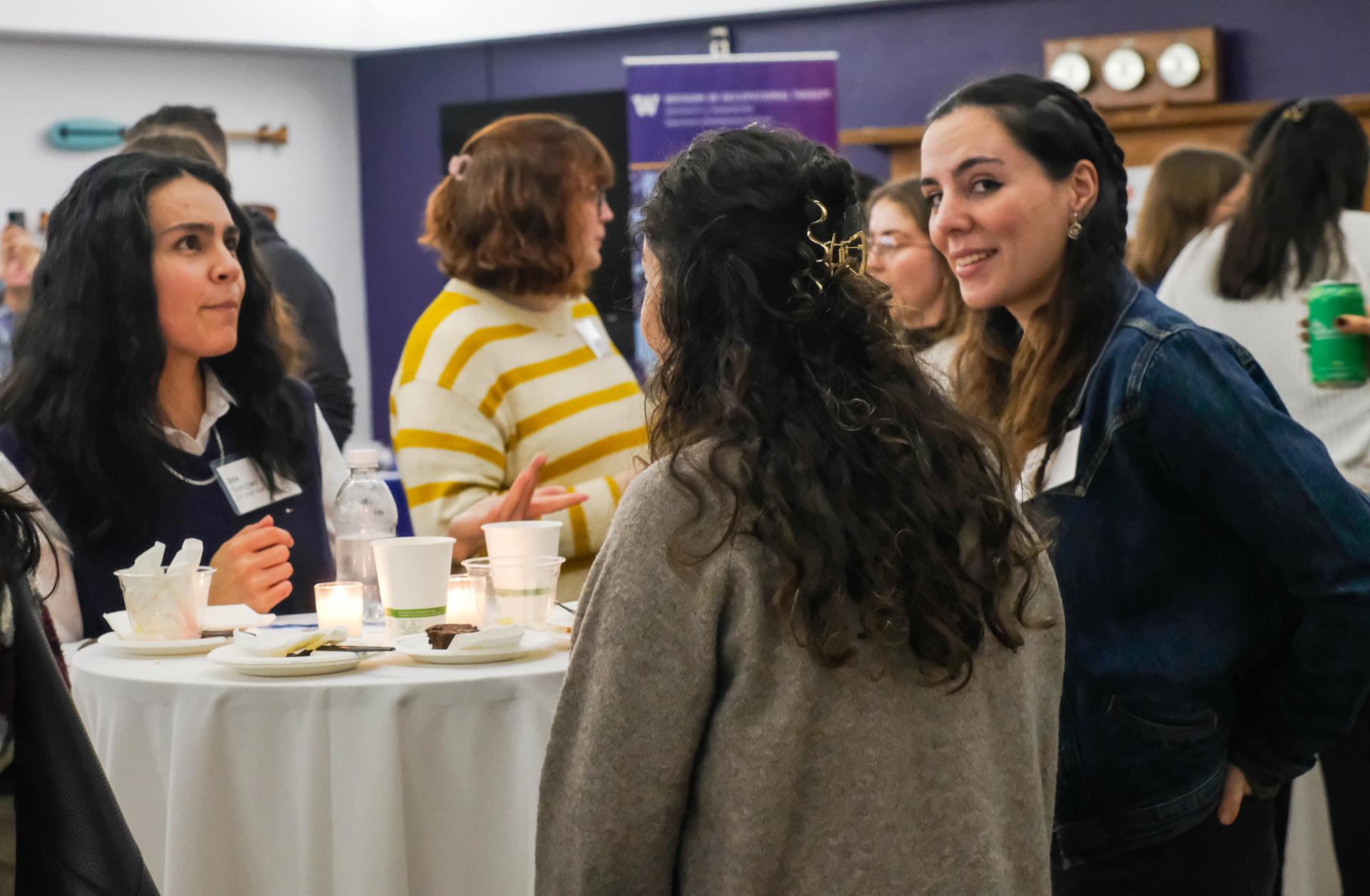 People chatting together in a crowded room. 