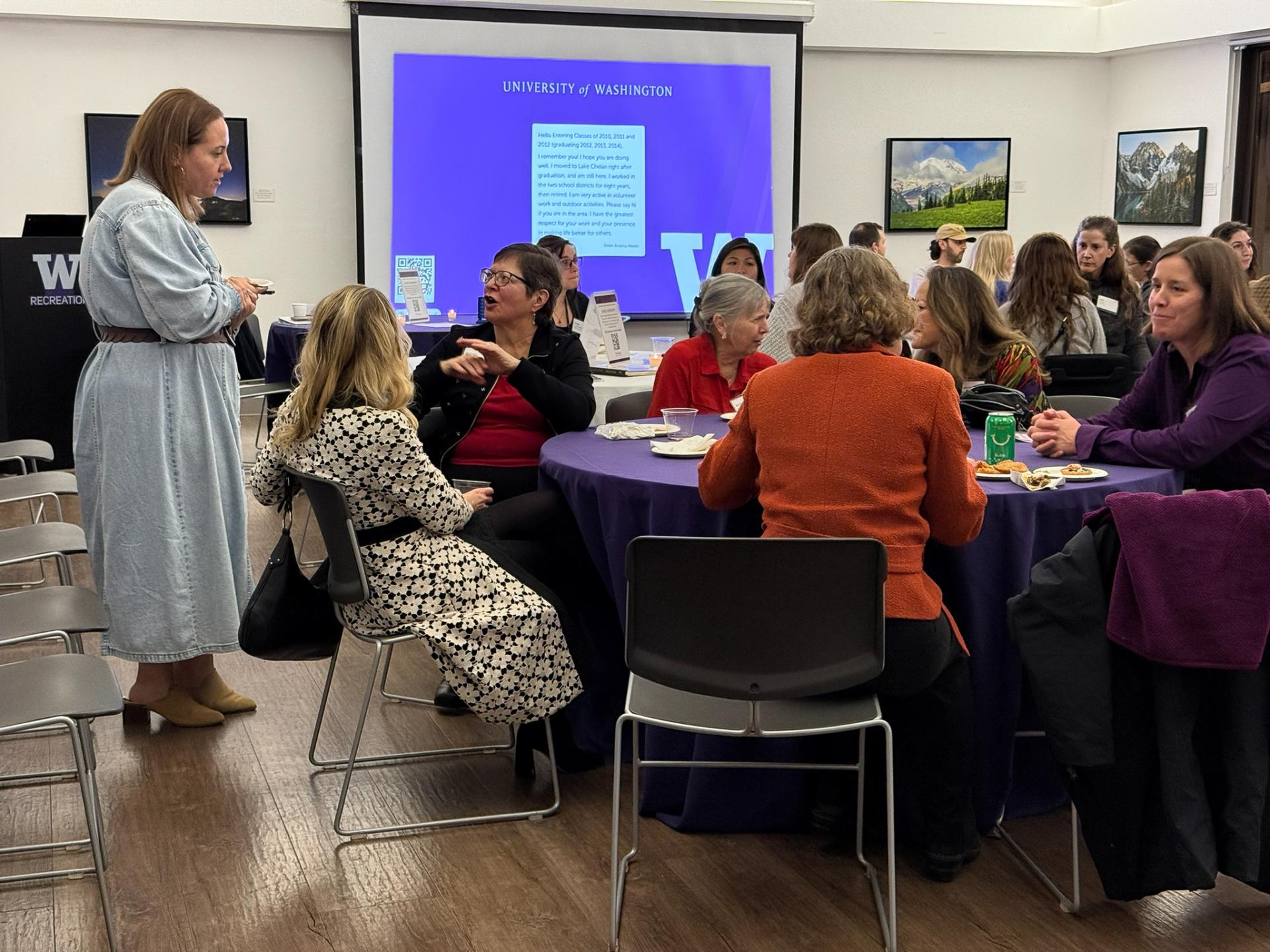People sit and chat in a crowded room. 