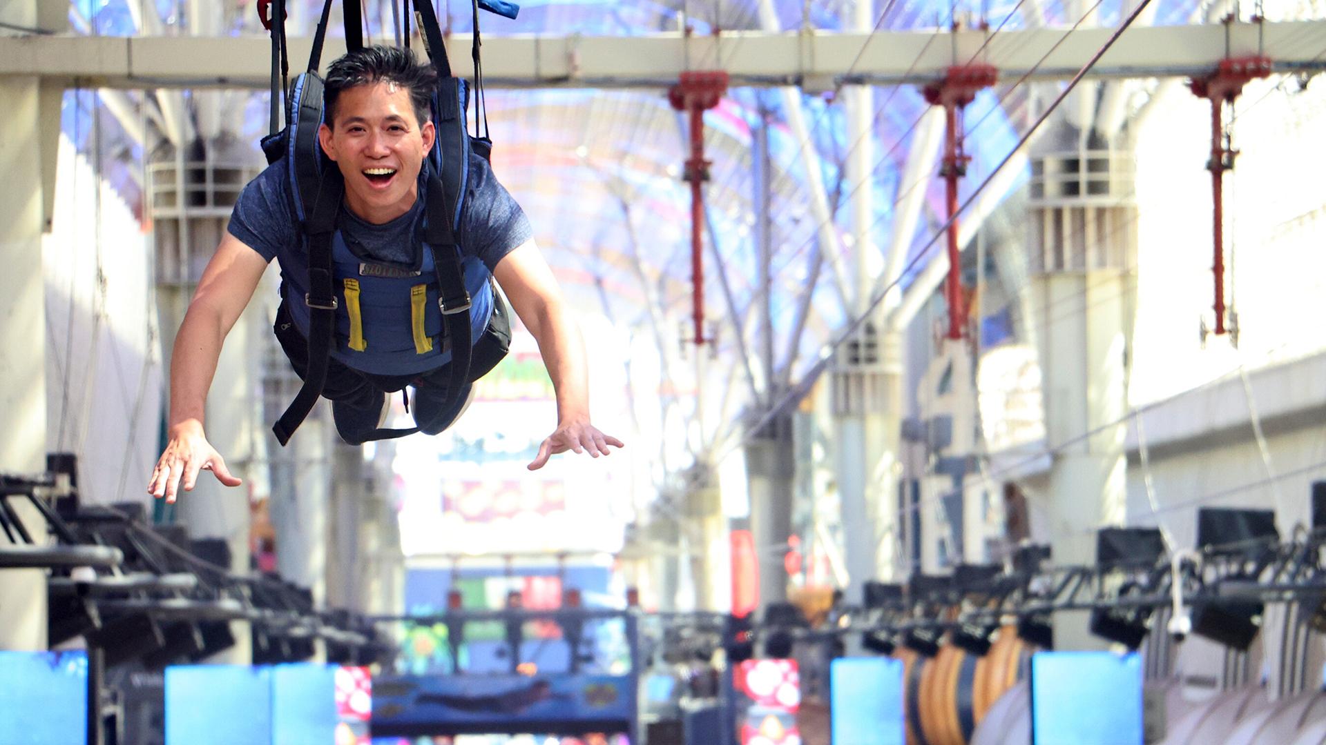 Dr. Liem dangles from a harness above a colorful market. 
