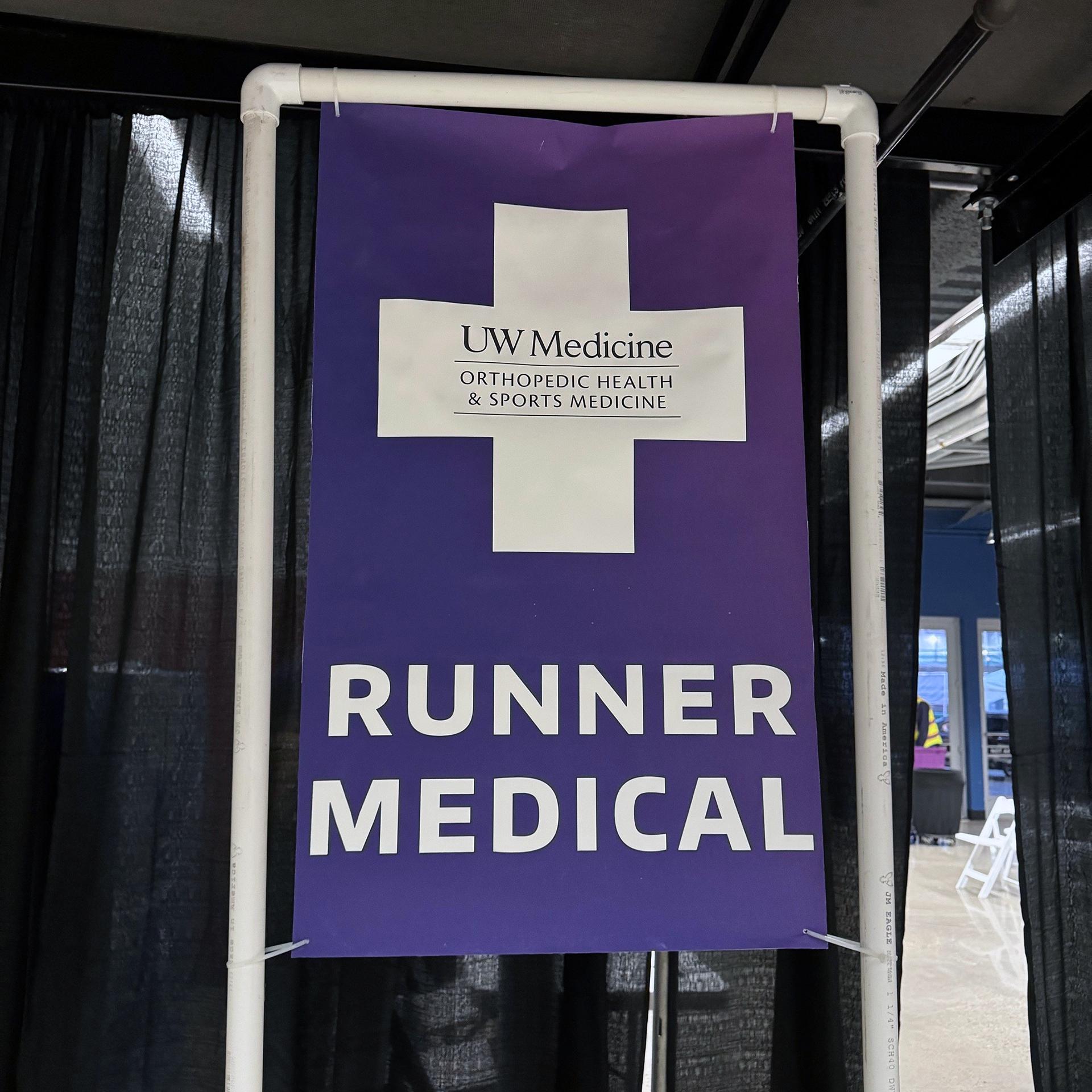 A purple banner with a white cross which says "Runner Medical"