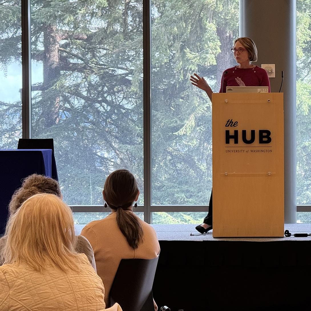 A woman gestures as she speaks to a crowd. 