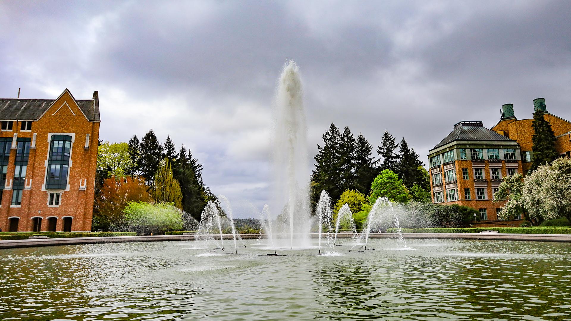 A fountain on UW campus under a cloudy sky.