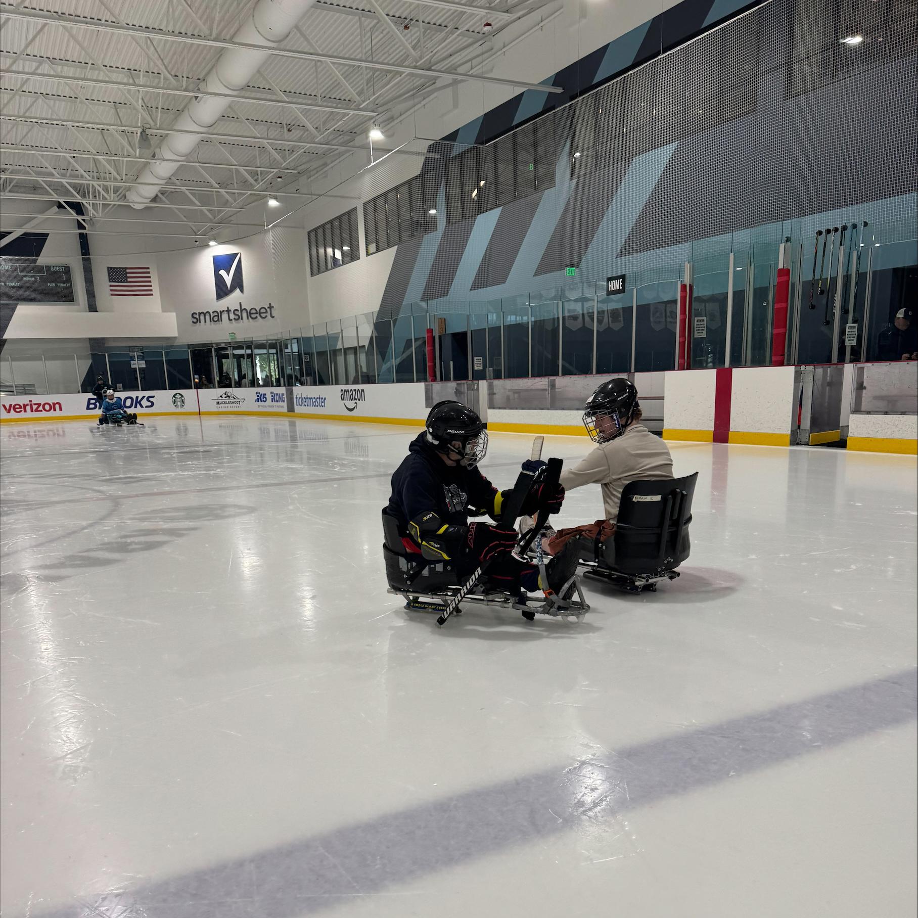 Two sled hockey athletes on the ice.