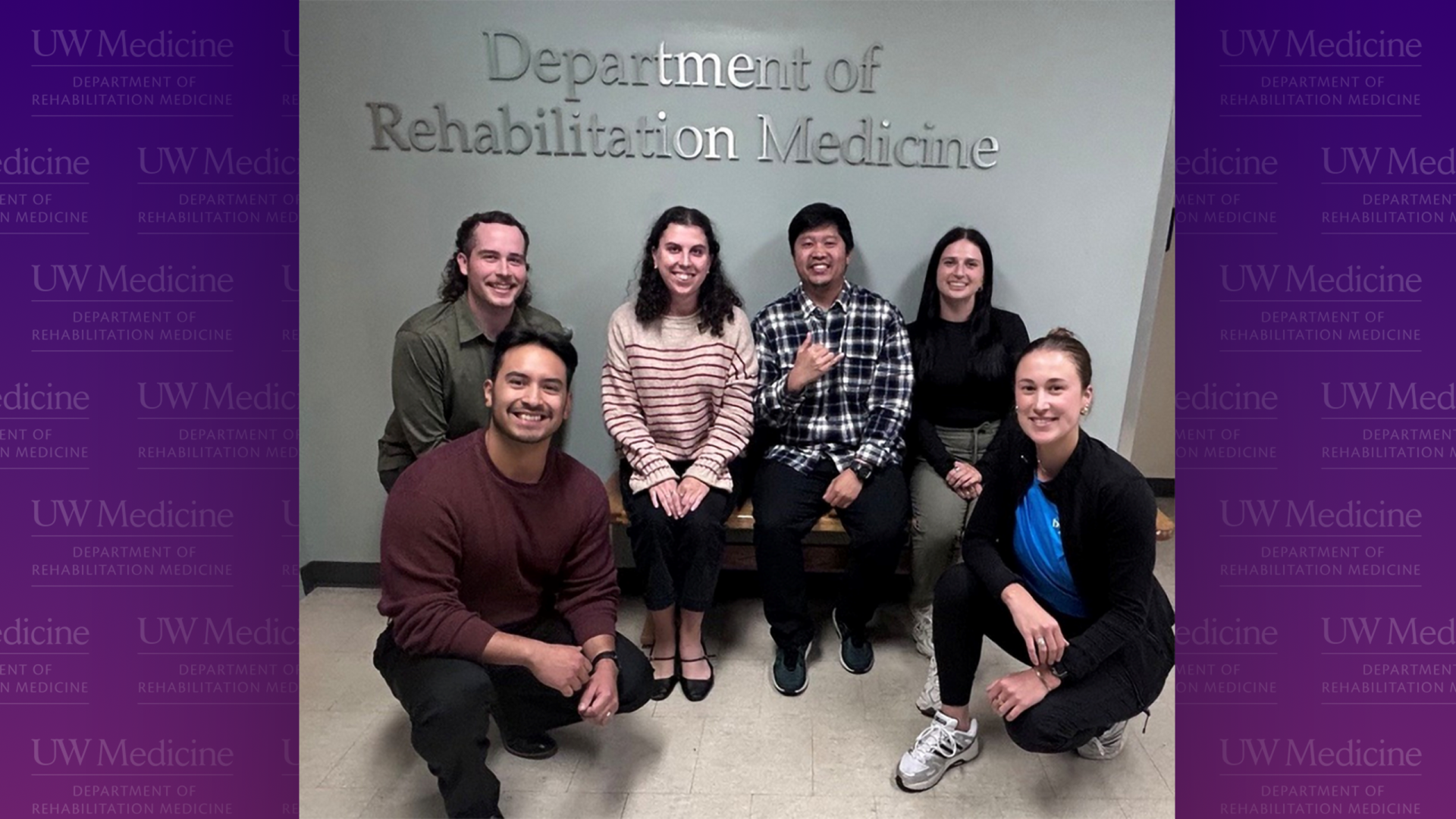 A group of six people smile under a Department of Rehabilitation Medicine sign.